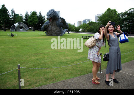 Tokyo, Japon. 18 juillet, 2014. Les gens prennent eux-mêmes des photos en face de l'6,6 mètre modèle du nouveau Godzilla à Tokyo Midtown le 18 juillet 2014, Tokyo. La statue est une reproduction de l'échelle de 1/7 180 mètres de hauteur Hollywood film version de 'GODZILLA'. Godzilla et ses empreintes de pas s'affiche du 18 juillet au 31 août au cours de laquelle il effectuera une présentation spéciale à l'aide de la brume, lumière et effets sonores toutes les 30 minutes entre 19:00 à 21:00. Credit : Rodrigo Reyes Marin/AFLO/Alamy Live News Banque D'Images