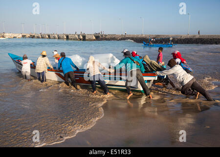 Jimbaran, Bali, Indonésie. Le lancement de bateau transportant de la glace sur les bateaux de pêche au large. Banque D'Images