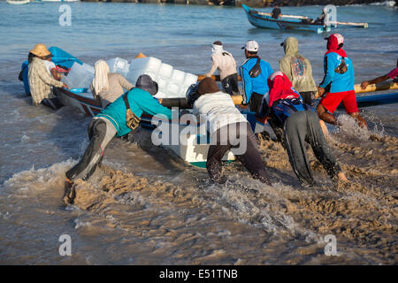 Jimbaran, Bali, Indonésie. Le lancement de bateau transportant de la glace sur les bateaux de pêche au large. Banque D'Images