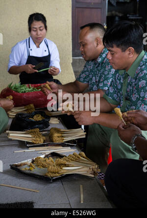 , Jatiluwih Bali, Indonésie. Mettre le poulet sur les brochettes, en préparation de Poulet Satay. Banque D'Images