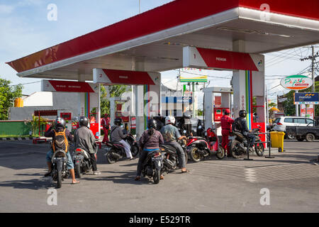 Bali, Indonésie. Les motos de l'alignement pour le carburant à la station de gaz. Banque D'Images