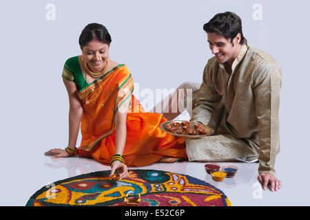 Couple Maharashtrian diyas mise sur rangoli Banque D'Images