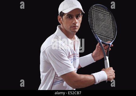 Portrait de l'homme jouant au tennis sur fond noir isolé Banque D'Images