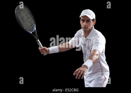 Portrait de l'homme jouant au tennis sur fond noir Banque D'Images