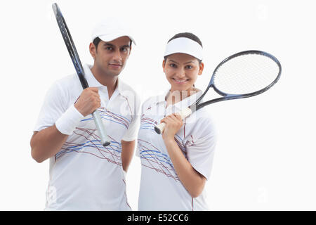 Portrait de l'homme et de la femme les joueurs de tennis raquettes holding isolated over white background Banque D'Images