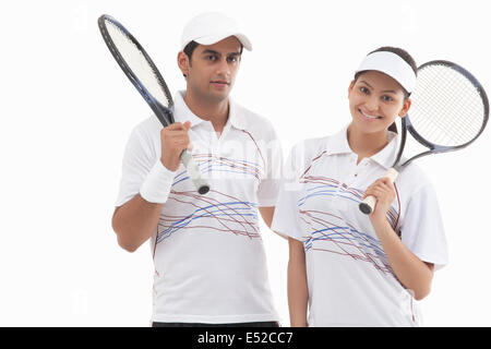 Portrait of man and woman holding isolé sur fond blanc Raquettes Banque D'Images