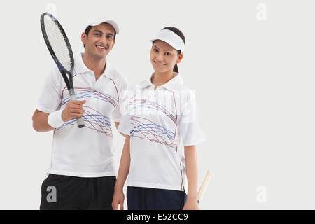 Portrait of male et femelle les joueurs de tennis se tenant ensemble isolé sur fond blanc Banque D'Images
