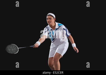 Jeune femme jouer au badminton sur fond noir Banque D'Images