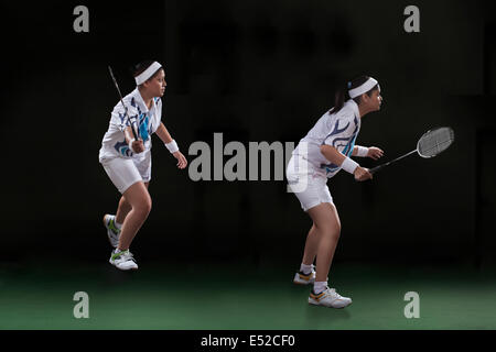 Photo de profil joueurs de jouer double badminton sur fond noir Banque D'Images