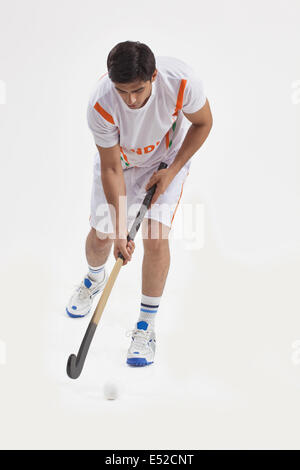 Young man playing field hockey isolé sur fond blanc Banque D'Images