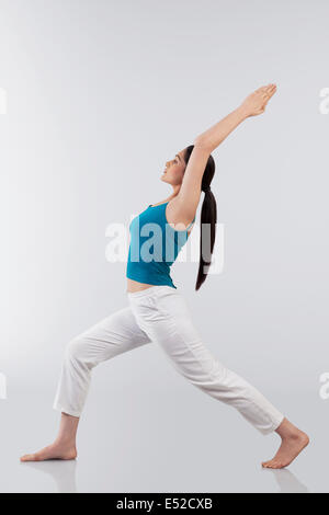 Photo de profil young woman doing back bend yoga pose sur plancher en bois Banque D'Images