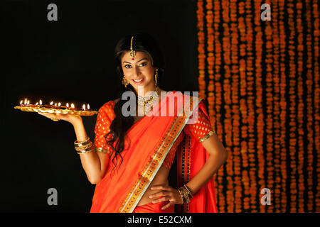 Portrait of a woman holding a tray de diyas Banque D'Images