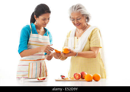 Grand-mère et petite-fille de fruits coupe Banque D'Images