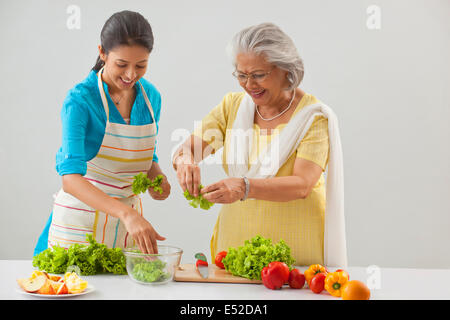 Grand-mère et petite-fille travaillant dans la cuisine Banque D'Images