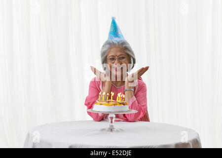 Femme posant avec son gâteau d'anniversaire Banque D'Images