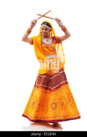 Full Length portrait of happy young woman playing Dandiya Raas isolé sur fond blanc Banque D'Images