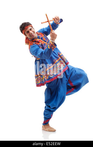 Portrait of happy young man in traditional porter exécution de Dandiya Rass sur fond blanc Banque D'Images