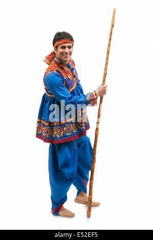 Full Length portrait of happy young man in traditional porter holding stick isolated over white background Banque D'Images
