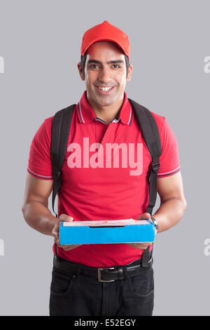 Portrait of pizza delivery man contre l'arrière-plan gris Banque D'Images