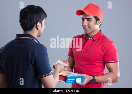 Young woman pizza delivery man sur fond gris Banque D'Images