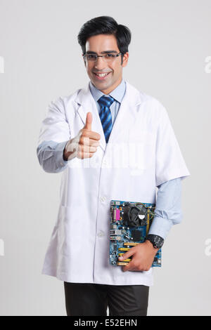 Portrait d'homme technician holding circuit board contre l'arrière-plan gris Banque D'Images