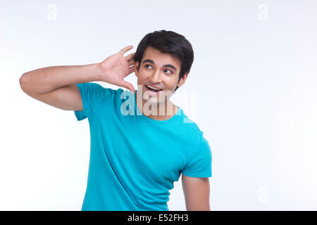 Surpris jeune homme écoute attentivement isolated over white background Banque D'Images