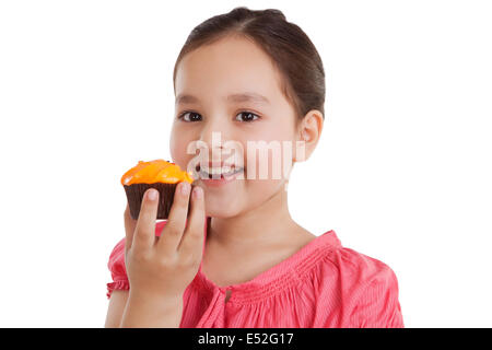 Portrait of a little girl eating a cupcake Banque D'Images