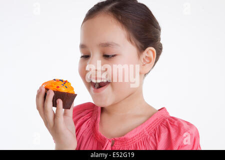 Little girl eating a cupcake Banque D'Images