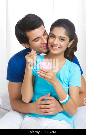 Jeune homme romantique avec woman eating ice-cream dans la chambre Banque D'Images