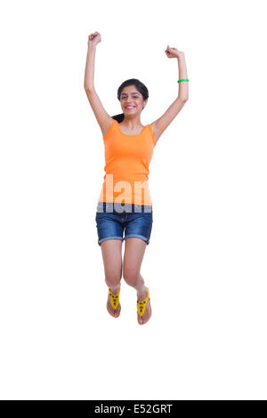 Toute la longueur de happy young woman jumping with arms raised over white background Banque D'Images
