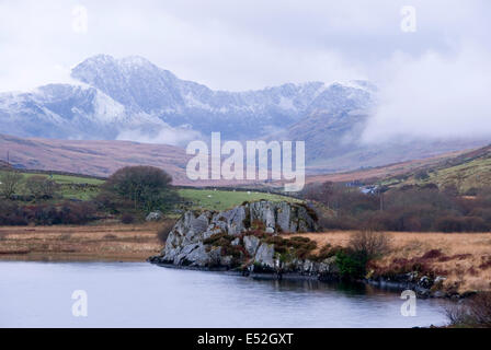 Snowdow vue à travers l'eau de Capel Curig lac sur un matin d'hiver brumeux, Galles, Royaume-Uni Banque D'Images