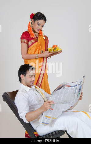 Femme de l'Inde du Sud avec un thali de lire un article dans un journal Banque D'Images