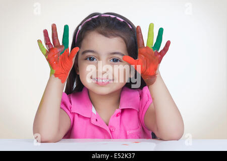 Portrait de jeune fille espiègle de couleur montrant paumes contre fond blanc Banque D'Images