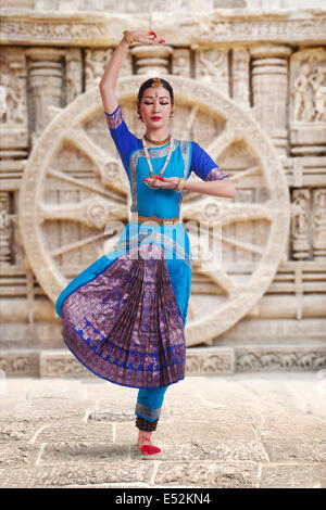 Toute la longueur de Bharat Natyam femelle dancer performing contre mur sculpté Banque D'Images