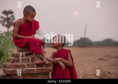 Deux jeunes moines profitez d'un moment ensemble à la fin de la journée quand le soleil se couche sur la plaine de Bagan au Myanmar. Banque D'Images