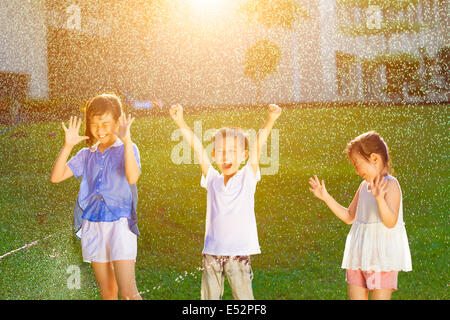 Happy kids a plaisir à jouer dans l'eau des fontaines Banque D'Images