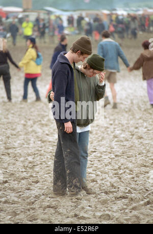 Couple debout dans la boue au Glastonbury Festival 1997, Somerset, Angleterre, Royaume-Uni. Banque D'Images