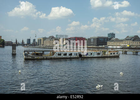 Bateau abandonné (navire) sur la rivière Spree près de Hoppetosse. Vue de l'Oberbaum bridge (Berlin). Banque D'Images