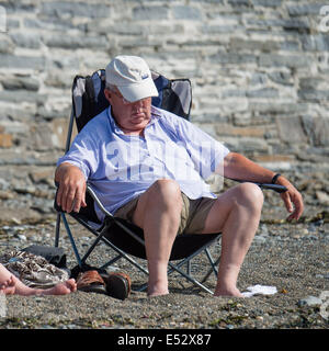 Aberystwyth, Pays de Galles, Royaume-Uni. 18 juillet, 2014. Météo : Sur un autre searingly chaud, avec des températures qui atteignent le haut 20s centigrades , un homme somnole au soleil sur la plage à Aberystwyth, sur la côte ouest du pays de Galles. Credit : Keith morris/Alamy Live News Banque D'Images