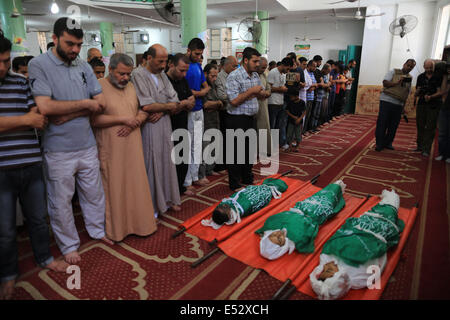 Gaza, bande de Gaza ville de Beit Lahia. 18 juillet, 2014. Les gens prient sur les corps de trois frères de la famille Abu Musallam, qui ont été tués dans un char israélien attaque, au cours de leurs funérailles au nord de la bande de Gaza ville de Beit Lahia, le 18 juillet 2014. Credit : Wissam Nassar/Xinhua/Alamy Live News Banque D'Images