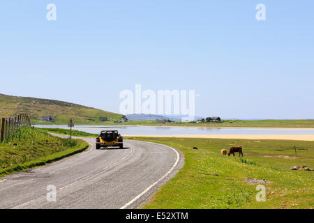 Voiture de sport à toit ouvert roulant sur une route côtière pays non clôturées par Scarasta Traigh beach Isle of Harris Outer Hebrides Scotland UK Banque D'Images