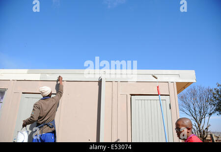 Johannesburg, Afrique du Sud. 18 juillet, 2014. Un bénévole peint le mur d'un orphelinat dans le bidonville de Tembisa à Johannesburg, Afrique du Sud, le 18 juillet 2014. Les gens en Afrique du Sud a célébré vendredi la Journée internationale Nelson Mandela en consacrant 67 minutes à faire des œuvres sociales pour le bien des autres. Zhang © Chuanshi/Xinhua/Alamy Live News Banque D'Images