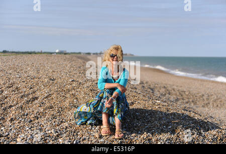 Aldeburgh Suffolk UK - vue sur la ville balnéaire de Suffolk D'Aldeburgh - femme assise sur la plage en vacances Banque D'Images