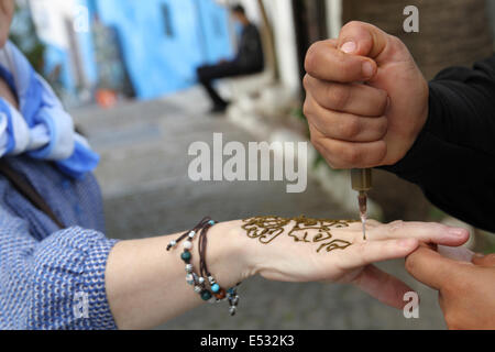 Une femme obtient un tatouage au henné sur la main au Maroc Banque D'Images