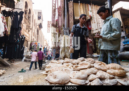 Scène de rue bazar avec enfant qui vend du pain. Caire islamique, l'Egypte Banque D'Images