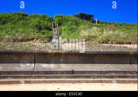 Un accès à la plage, au-dessus de la mer mur avec une maison d'été dans les dunes au Panier vide, près de l'Happisburgh, Norfolk, Angleterre, Royaume-Uni. Banque D'Images