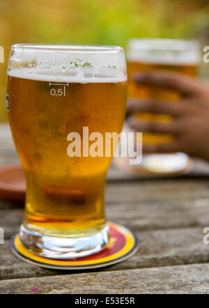 Les pintes de bière blonde s'assit sur une table de pub Banque D'Images