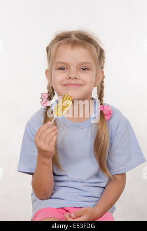 La fillette de cinq ans mange avec enthousiasme candy Banque D'Images