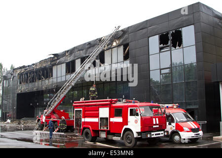 Deux camions de pompiers près du complexe sportif Donbass après l'incendie au cours d'une confrontation militaire en Ukraine Banque D'Images