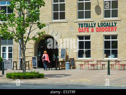 Femme marche dans cafe dans le complexe du Moulin Dean Clough, Halifax, West Yorkshire, England UK Banque D'Images